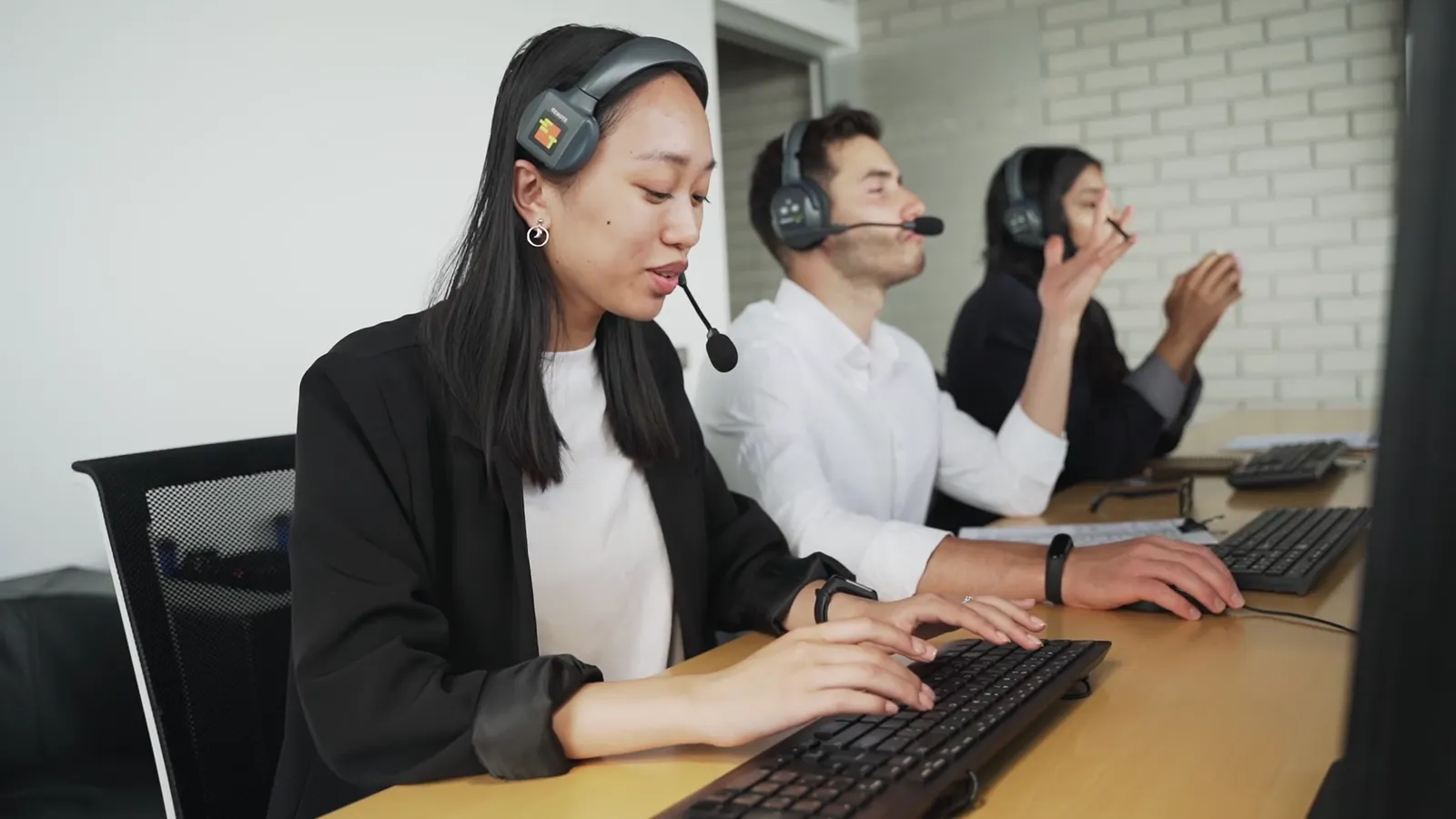 Customer support team wearing headsets in a bright office